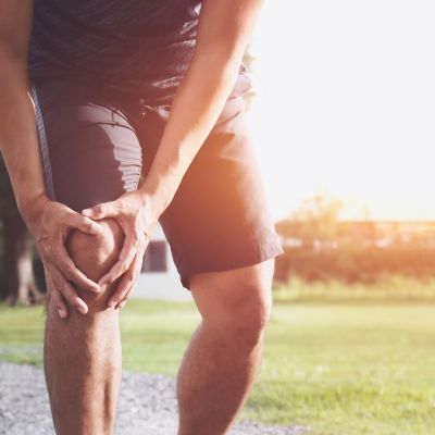 man holding knee in pain